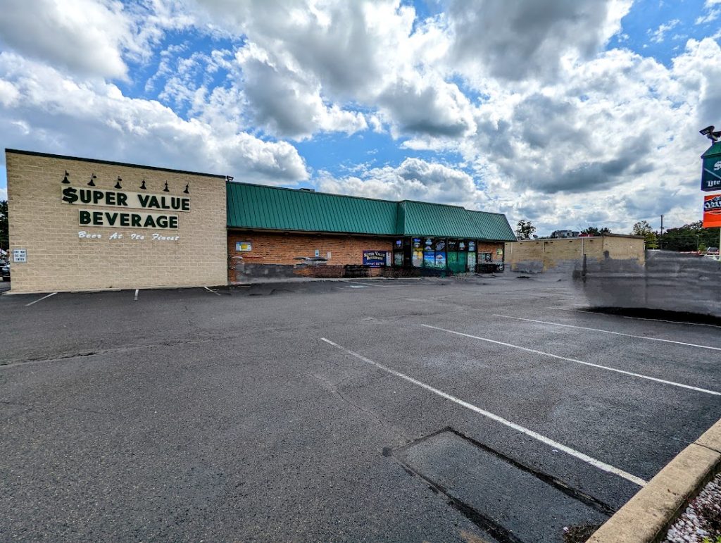 A store with a parking lot and a cloudy sky.