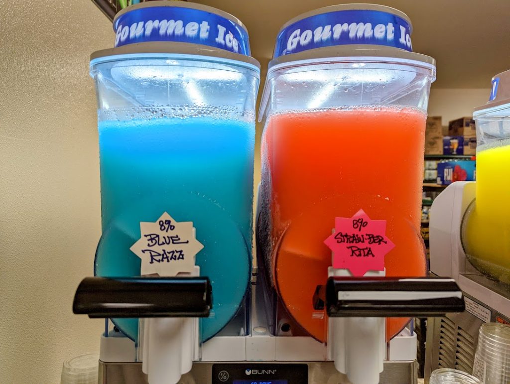 Two soda dispensers with different colored liquids.